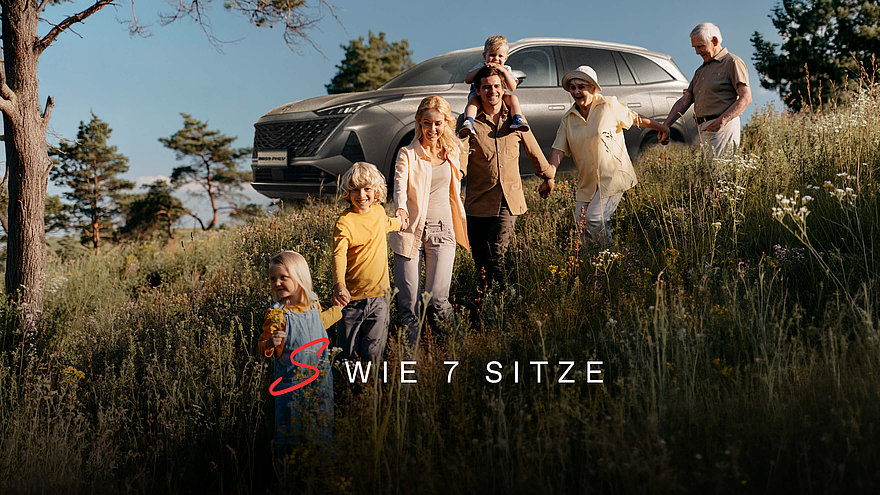 MGS9 PHEV an Berghang stehend, davor eine siebenköpfige Familie, die sich an den Händen hält