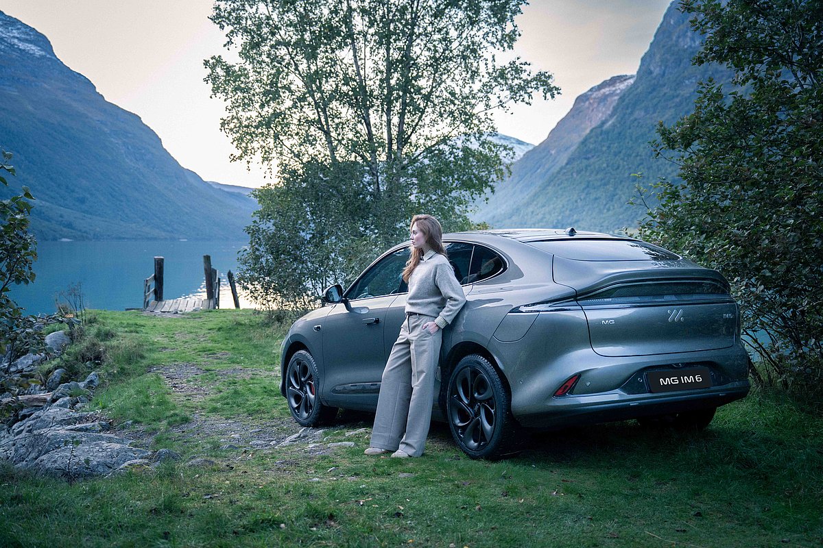 MG IM6 in Rembrandt Grey, Natur, Berglandschaft, Frau lehnt am Auto