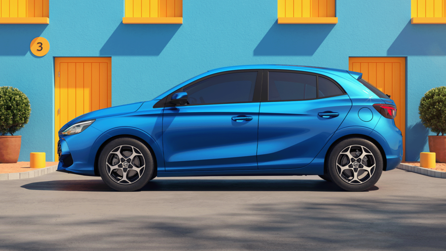 MG3 in Como Blue vor hellblauem Haus mit gelben Fenstern und Türen, seitliche Ansicht